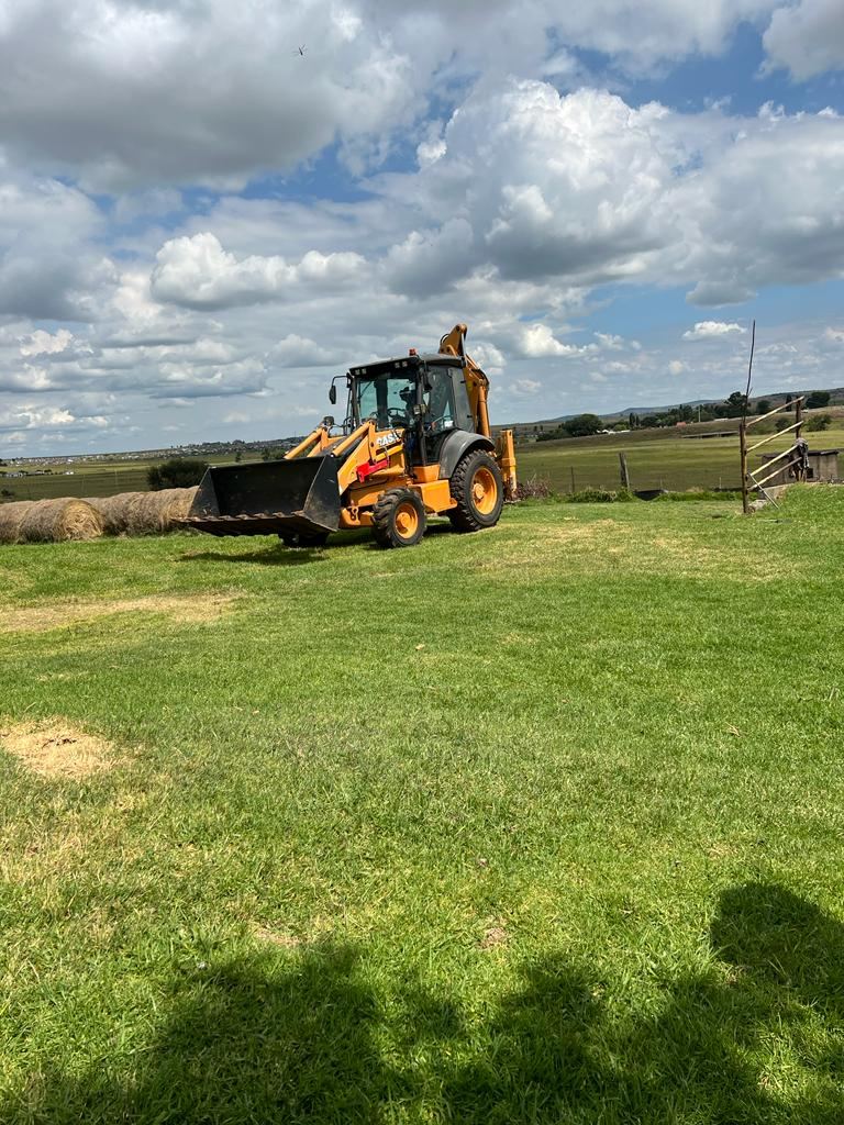 Paul Plant Hire tractor loader backhoe (TLB) operating on open farmland
